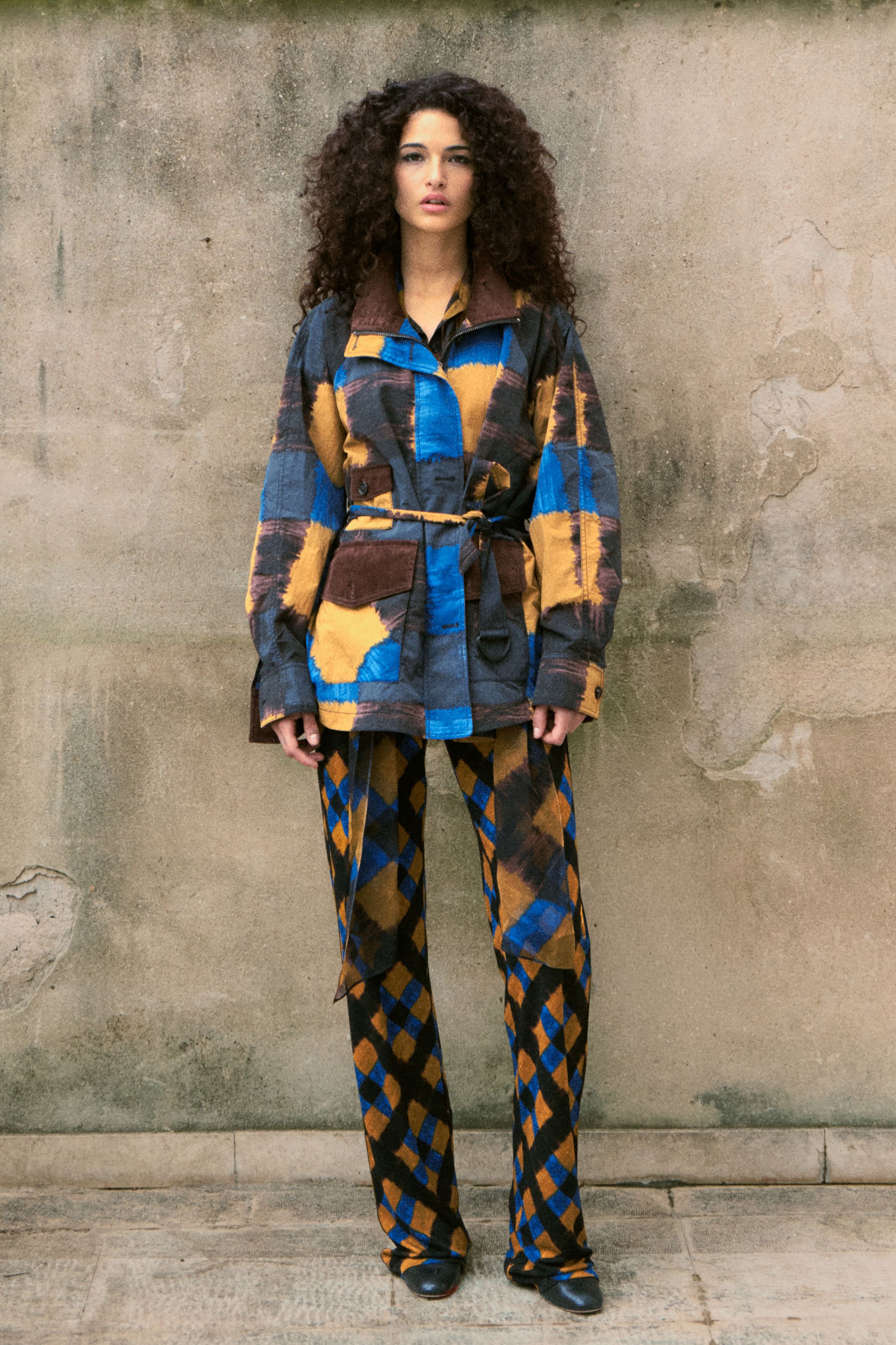 Diane von Furstenberg本季延续品牌标志性的印花语言，以丰富图案与复古色彩打造充满活力的女性形象。黄色、蓝色与红色几何印花在连衣裙与套装中形成鲜明视觉节奏，展现DVF一贯的自由精神。流动面料与修长轮廓让服装在行走间充满律动，使整个系列既具有复古魅力，也保持现代女性的自信与独立气质力-顽石频道趋势研究